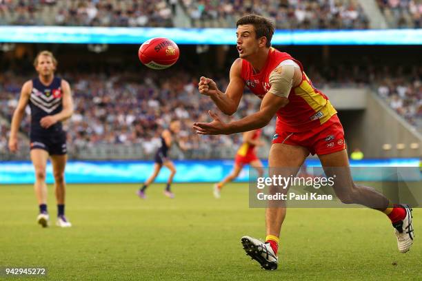 Jarryd Lyons of the Suns handballs during the round three AFL match between the Gold Coast Suns and the Fremantle Dockers at Optus Stadium on April...