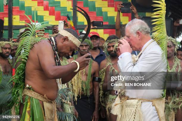 Britain's Prince Charles drinks kava with Chief Seni Mao Tirsupe, the President of the Malvatumauri Council of Chiefs, to the Chief's Nakamal in Port...