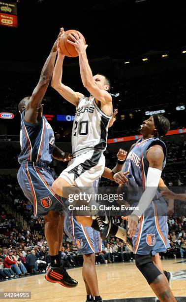 Manu Ginobili of the San Antonio Spurs shoots against Acie Law of the Charlotte Bobcats on December 11, 2009 at the AT&T Center in San Antonio,...