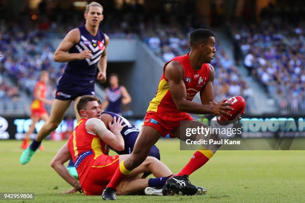 Touk Miller of the Suns looks to pass the ball during the round three AFL match between the Gold Coast Suns and the Fremantle Dockers at Optus...