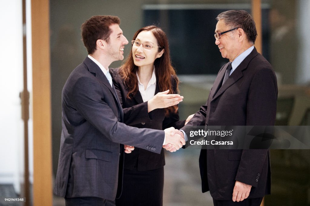 Caucasian Businessman closing a deal in Hong Kong with his Asian colleagues