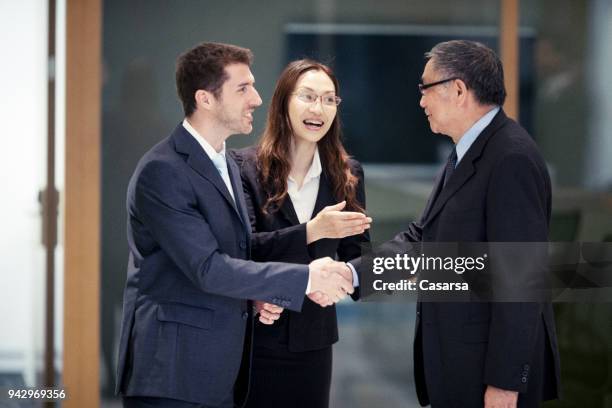 kaukasische geschäftsmann schließen einen vertrag in hongkong mit seinen asiatischen kollegen - übersetzung stock-fotos und bilder