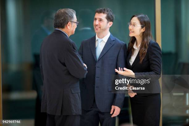 kaukasische geschäftsmann mit seinem dolmetscher einen deal mit senior asiatischen geschäftsmann zu diskutieren - übersetzung stock-fotos und bilder