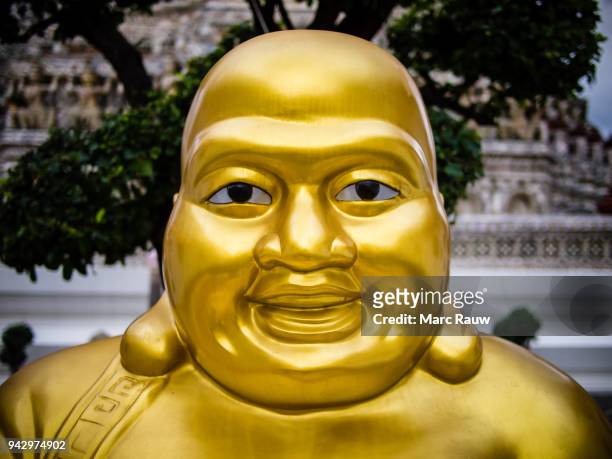 happy golden chinese buddha sculpture at the wat arun temple in bangkok - buddha face stockfoto's en -beelden