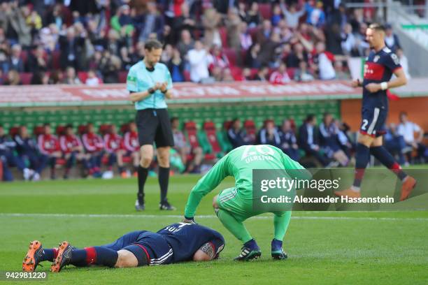 Niklas Suele of Bayern Muenchen lies on the pitch after scoring an own goal to make it 1:0, while goalkeeper Sven Ulreich of Bayern Muenchen checks...