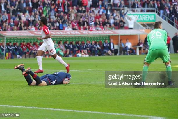 Niklas Suele of Bayern Muenchen lies on the pitch after scoring an own goal to make it 1:0, while goalkeeper Sven Ulreich of Bayern Muenchen looks on...