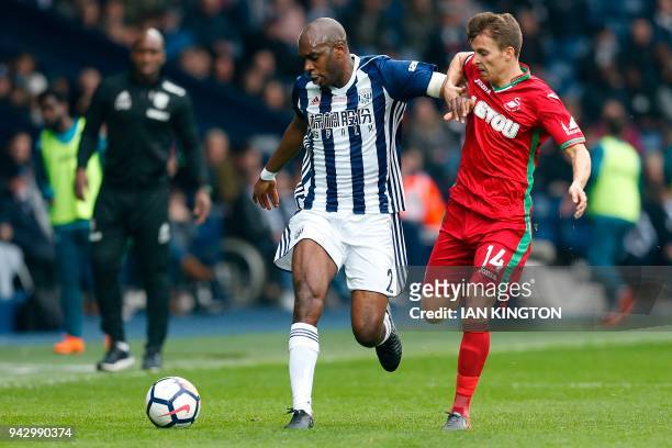 West Bromwich Albion's French-born Cameroonian defender Allan Nyom vies with Swansea City's English midfielder Tom Carroll during the English Premier...