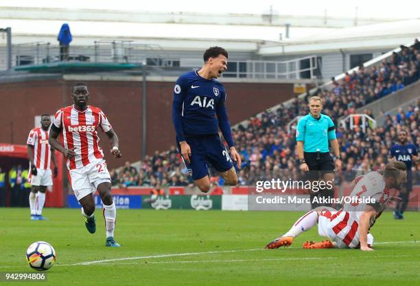 Dele Alli of Tottenham Hotspur reacts after a challenge from Erik Pieters of Stoke City during the Premier League match between Stoke City and...