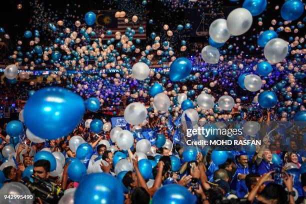 Supporters of the ruling National Front coalition, or Barisan Nasional, wave party's flag after Malaysian Prime Minister Najib Razak launching his...