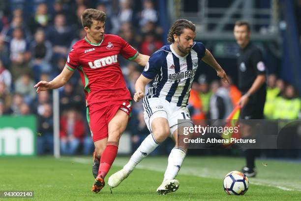 Tom Carroll of Swansea City challenges Jay Rodriguez of West Bromwich Albion during the Premier League match between Swansea City and West Bromwich...