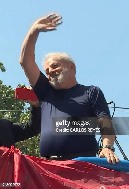 This screen grab shows Brazilian ex-president Luiz Inacio Lula da Silva waving to supporters at the metalworkers' union building in Sao Bernardo do...