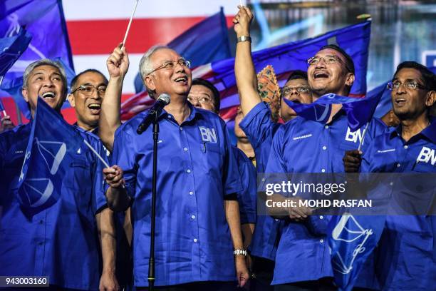 Malaysian Prime Minister Najib Razak sings the party's anthem after launching his coalition's election manifesto ahead of the upcoming polls during a...