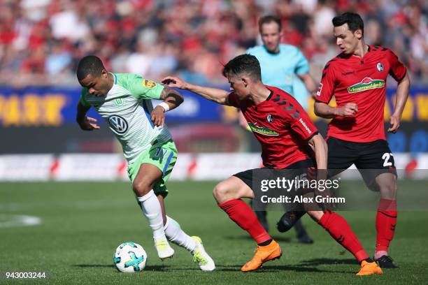 Daniel Didavi of Wolfsburg is challenged by Robin Koch of Freiburg during the Bundesliga match between Sport-Club Freiburg and VfL Wolfsburg at...