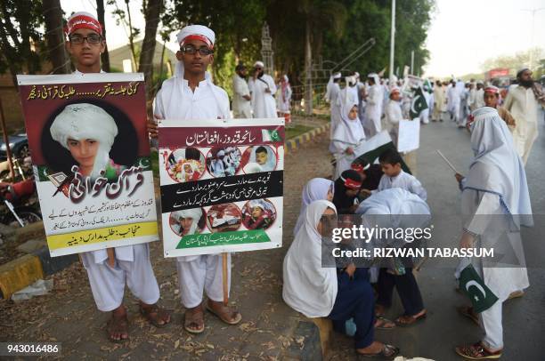 Pakistani religious students hold placards during a demonstration against the April 2 Afghan airstrike in the northeastern province of Kunduz in...