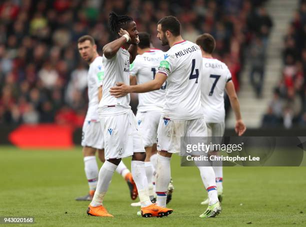 Wilfried Zaha of Crystal Palace celebrates with teammate Luka Milivojevic after scoring his sides second goal during the Premier League match between...