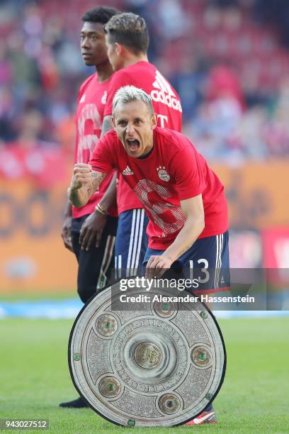 Rafinha of Bayern Muenchen celebrates with a replica of the champions trophy after Munechen won the 6th championship back to back, after the...