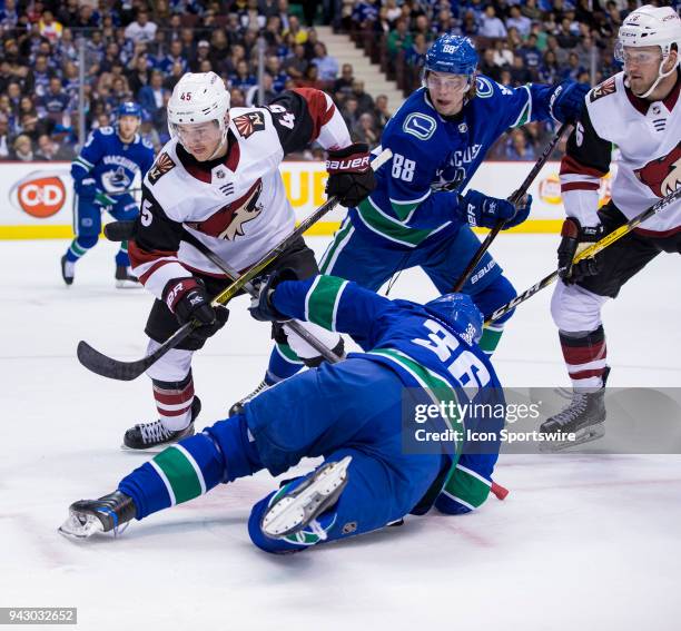 Arizona Coyotes Center Josh Archibald and Defenceman Jakob Chychrun battle with Vancouver Canucks Left Wing Jussi Jokinen and Center Adam Gaudette...