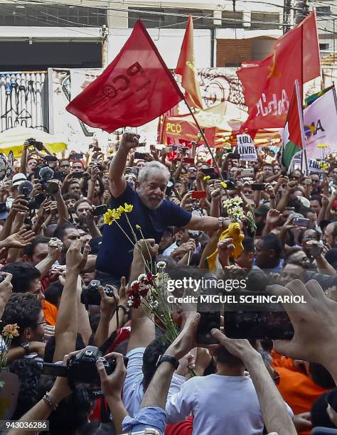 Brazilian ex-president Luiz Inacio Lula da Silva raises his fist after attending a Catholic Mass in memory of his late wife Marisa Leticia, at the...