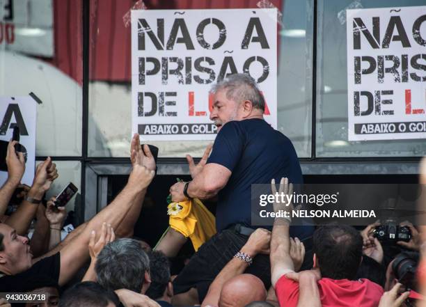 Brazilian ex-president Luiz Inacio Lula da Silva is carried by supporters after attending a Catholic Mass in memory of his late wife Marisa Leticia,...