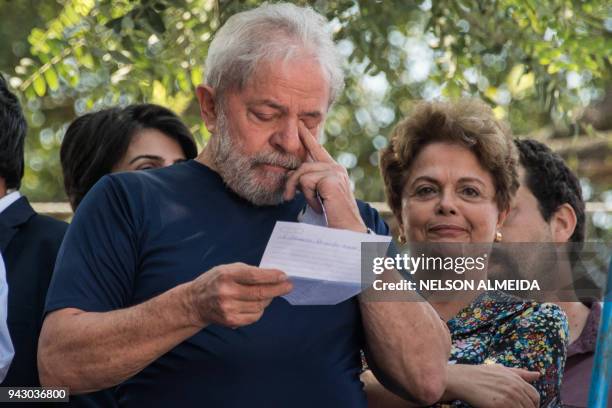 Brazilian ex-president Luiz Inacio Lula da Silva gestures next to Brazilian former president Dilma Rousseff after attending a Catholic Mass in memory...