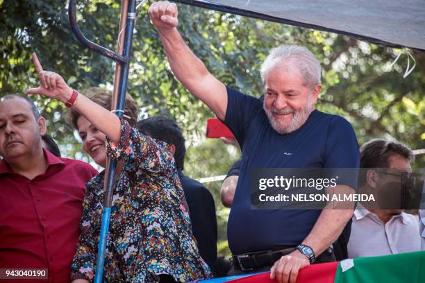 Brazilian former president Luiz Inacio Lula da Silva raises his fist next to Brazilian former president Dilma Rousseff during a Catholic Mass in...