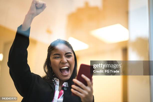 aziatische zakenvrouw vieren met mobiele telefoon - business woman cheering stockfoto's en -beelden