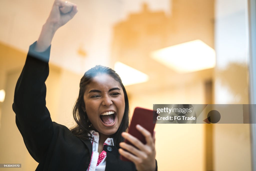 Asian Business Woman Celebrating with Mobile Phone