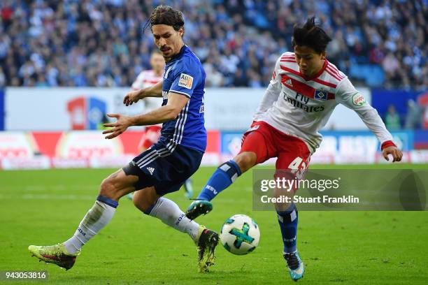 Tatsuya Ito of Hamburg fights for the ball with Benjamin Stambouli of Schalke during the Bundesliga match between Hamburger SV and FC Schalke 04 at...