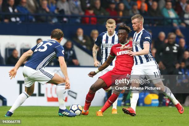 Tammy Abraham of Swansea City is challenged by Craig Dawson and Chris Brunt of West Bromwich Albion during the Premier League match between Swansea...