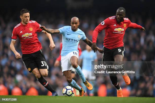 Fabian Delph of Manchester City runs with the ball under pressure from Nemanja Matic of Manchester United and Romelu Lukaku of Manchester United...