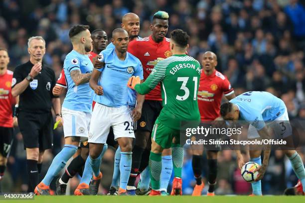 Man City goalkeeper Ederson intervenes as Paul Pogba of Man Utd argues with Fernandinho of Man City during the Premier League match between...