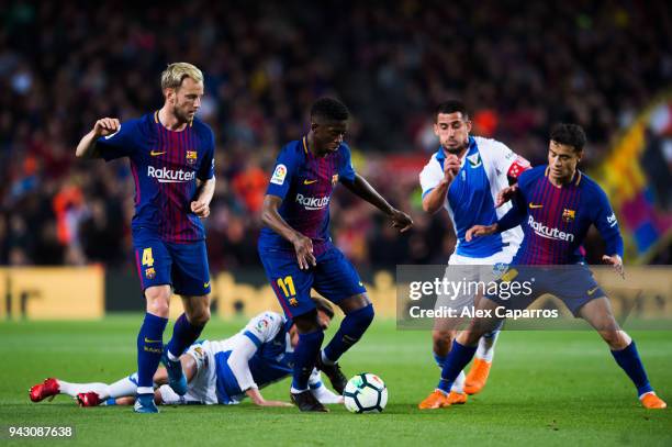 Ousmane Dembele of FC Barcelona conducts the ball among his teammates Ivan Rakitic and Philippe Coutinho and Gabriel Pires of CD Leganes during the...