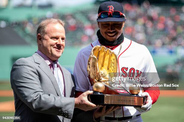 Mookie Betts of the Boston Red Sox is presented with the 2017 Gold Glove award before a game against the Tampa Bay Rays on April 7, 2018 at Fenway...