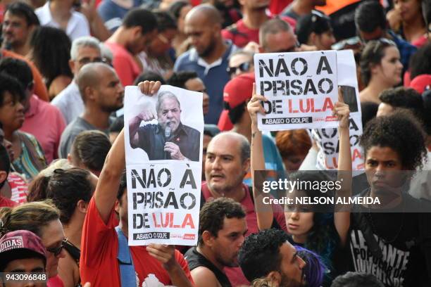 Supporters of Brazilian ex-president Luiz Inacio Lula da Silva hold signs while they block the metalworkers' union building in Sao Bernardo do Campo,...