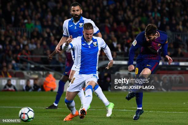 Barcelona's Argentinian forward Lionel Messi scores a goal past Leganes' Spanish defender Raul Garcia and Leganes' Greek defender Dimitrios Siovas...