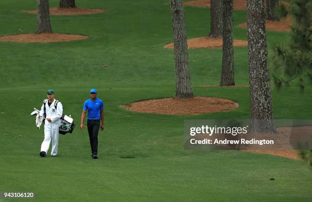 Tony Finau of the United States walks with caddie Gregory Bodine on the seventh hole during the third round of the 2018 Masters Tournament at Augusta...