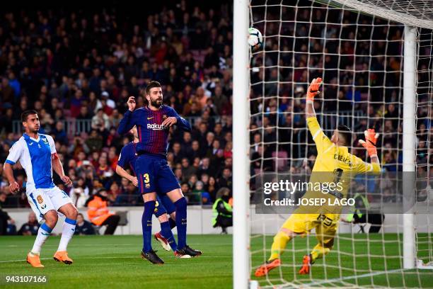 Leganes' Spanish goalkeeper Pichu Cuellar prepares to block a shot on goal by Barcelona's Spanish defender Gerard Pique next to Leganes' Brazilian...