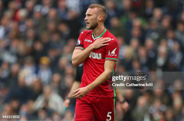 An injured Mike van der Hoorn of Swansea City holds his shoulder before being substituted during the Premier League match between West Bromwich...