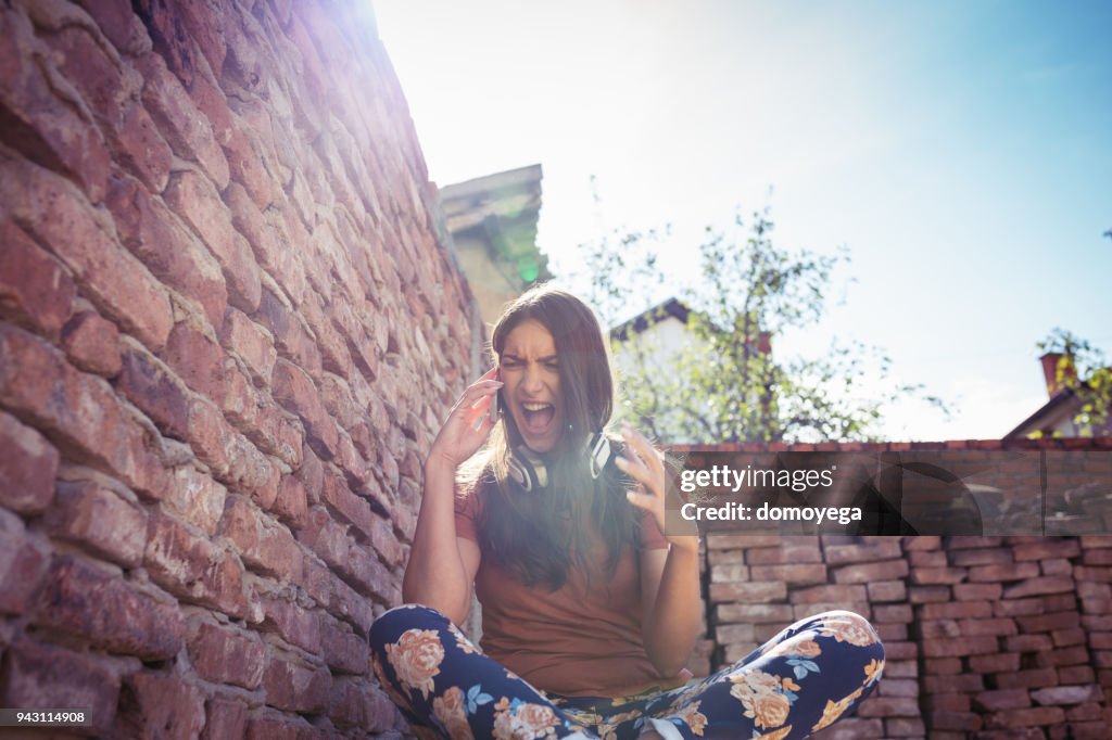 Angry woman talking on the phone outdoors