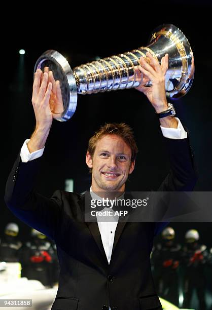 British Formula One driver Jenson Button holds up his FIA Formula One World Championship trophy during the 2009 FIA prize presentation gala on...