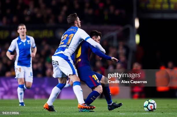 Ruben Perez of CD Leganes fouls Lionel Messi of FC Barcelona during the La Liga match between Barcelona and Leganes at Camp Nou on April 7, 2018 in...