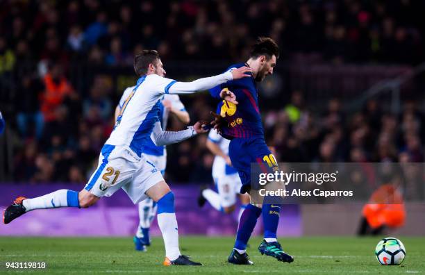 Ruben Perez of CD Leganes fouls Lionel Messi of FC Barcelona during the La Liga match between Barcelona and Leganes at Camp Nou on April 7, 2018 in...