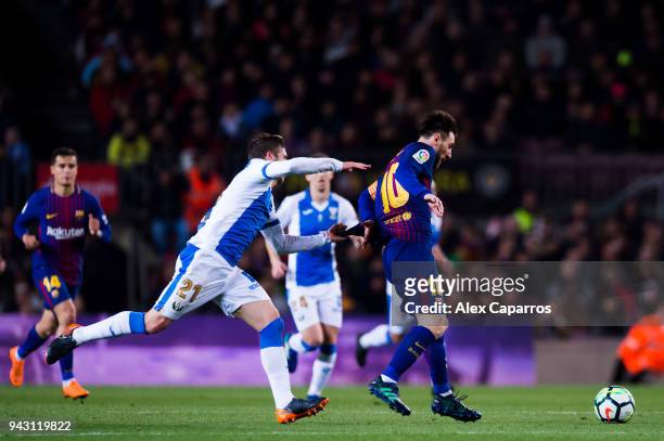 Ruben Perez of CD Leganes fouls Lionel Messi of FC Barcelona during the La Liga match between Barcelona and Leganes at Camp Nou on April 7, 2018 in...