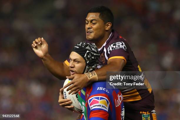 Kalyn Ponga of the Knights is tackled by Anthony Milford of the Broncos during the round five NRL match between the Newcastle Knights and the...