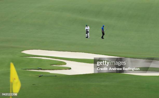 Tony Finau of the United States walks on the tenth hole with caddie Gregory Bodine during the third round of the 2018 Masters Tournament at Augusta...