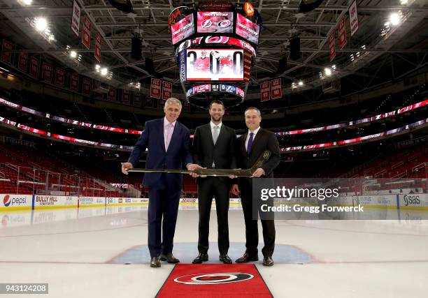 Ron Francis, President of Hockey Operations for the Carolina Hurricanes and Assistant General Manager Brian Tatum present Hurricanes goaltender Cam...
