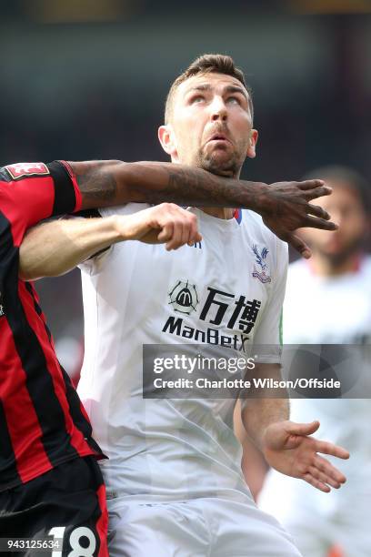 The arm of Jermain Defoe of Bournemouth holds James McArthur of Crystal Palace back as he looks up for the ball during the Premier League match...