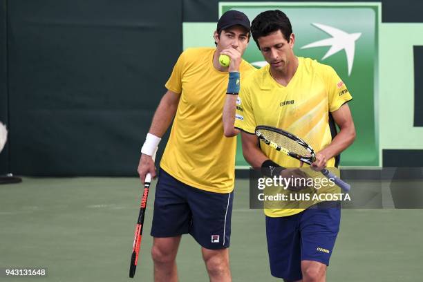 Brazilian tennis player Marcelo Demoliner speaks with his teammate Marcelo Melo during their Americas Zone Group I, 2nd round Davis Cup tennis...