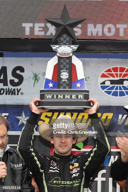 Ryan Blaney, driver of the Fitzgerald Glider Kits Ford, celebrates with the trophy in Victory Lane after winning the NASCAR Xfinity Series My...