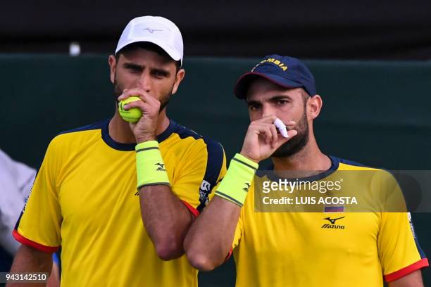 Colombian tennis player Robert Farah speaks with his teammate Juan Sebastian Cabal during their Americas Zone Group I, 2nd round Davis Cup tennis...